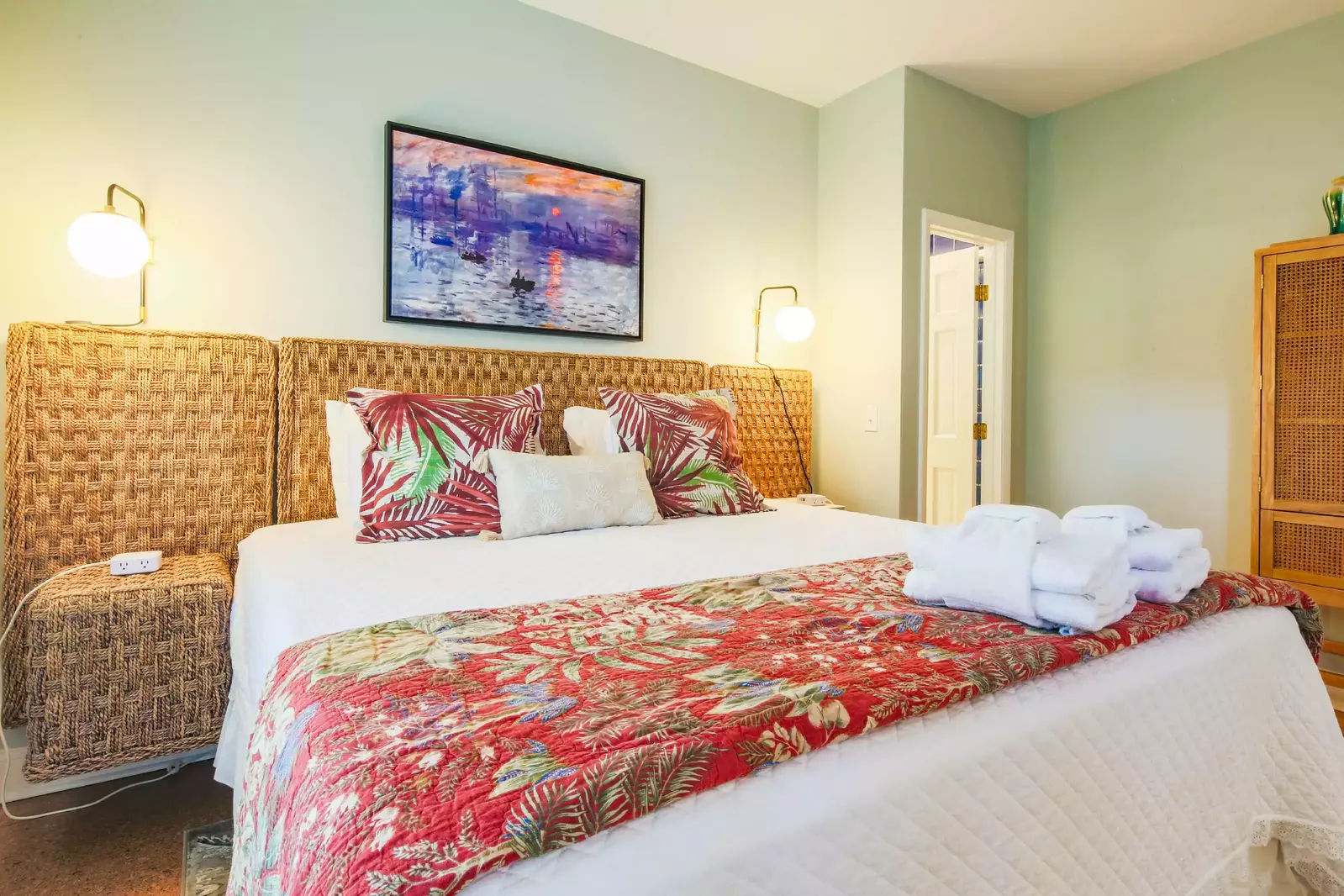 The guest bedroom features tropical-themed decor and wicker furniture.