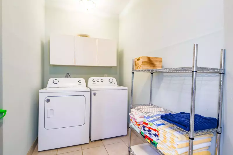 There is a full-sized washing machine and dryer near the laundry room.