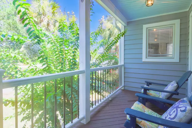 There are adirondack chairs on the front porch.