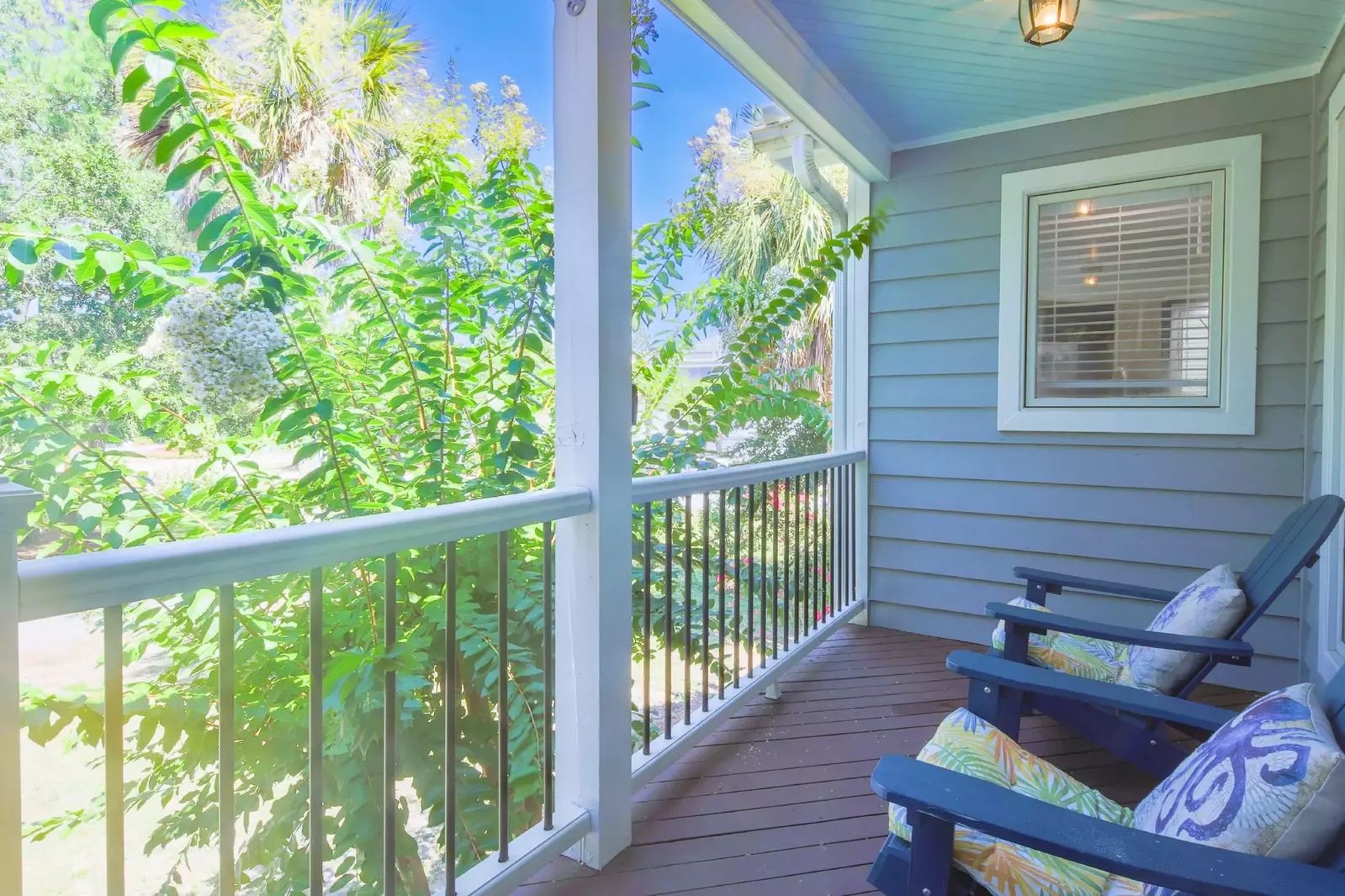 There are adirondack chairs on the front porch.