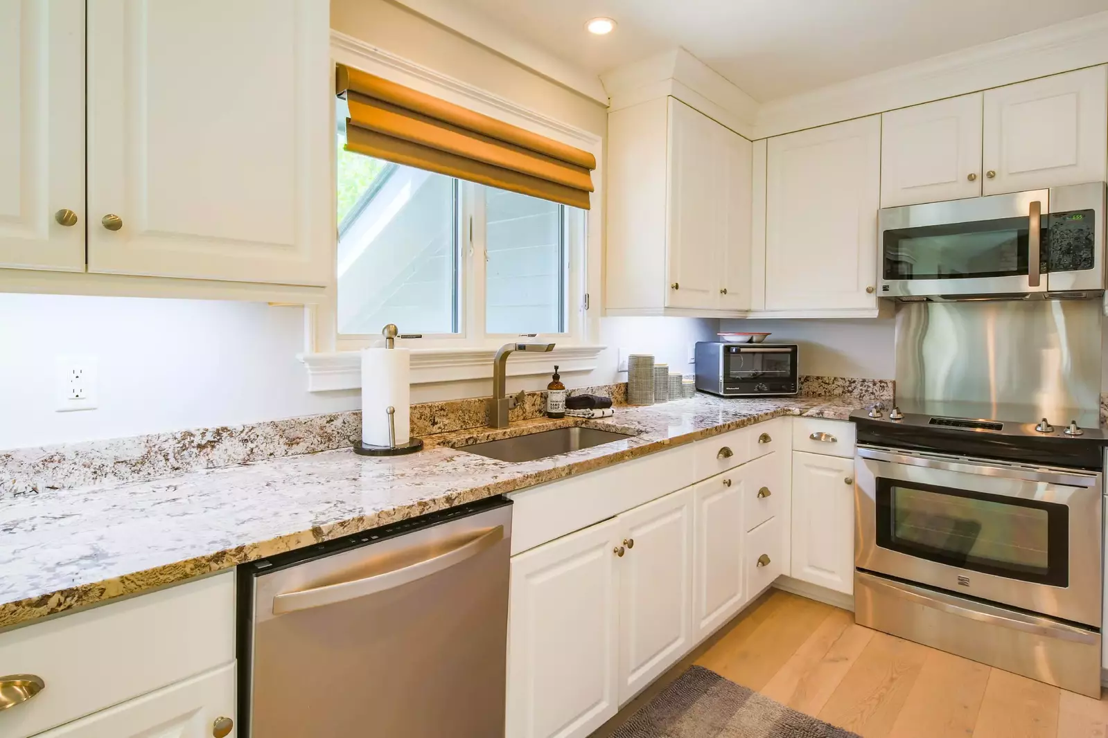 The kitchen features granite counters and stainless steel appliances.