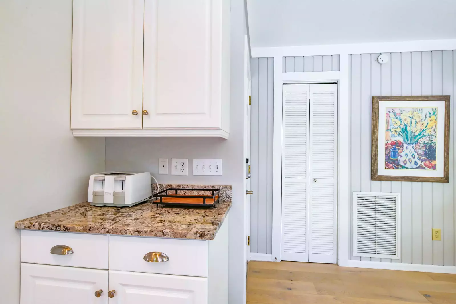 There is a toaster and additional storage near the refrigerator.