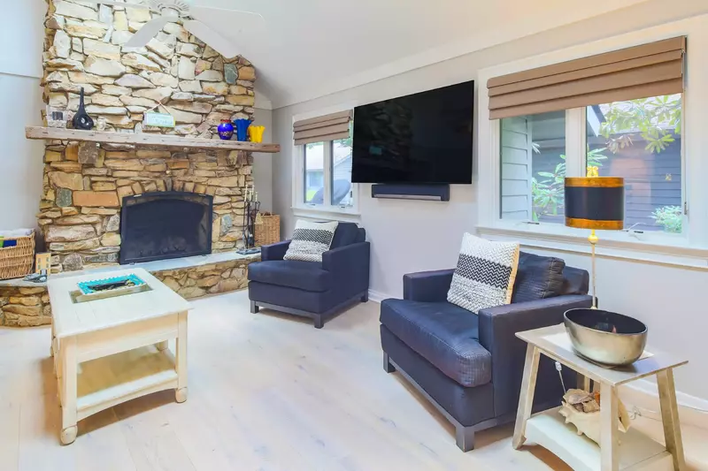 The living room features white oak flooring and a wall-mounted TV.
