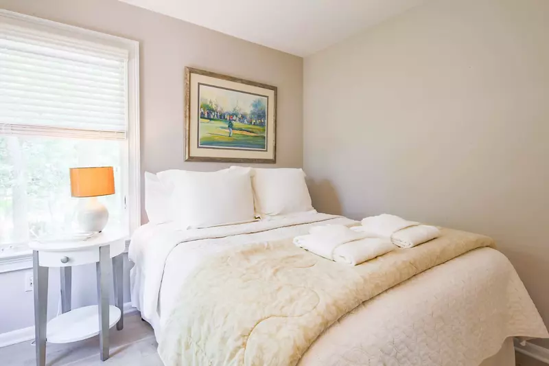 The third bedroom features a queen bed and night stand with reading lamp.
