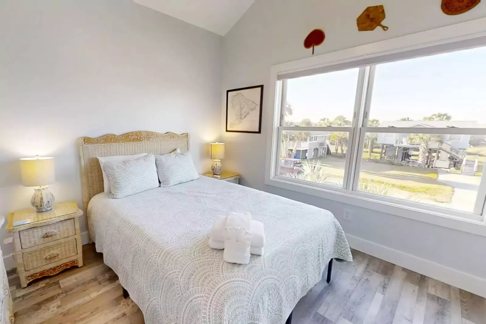 This guest bedroom features a queen bed and night stands with reading lamps.