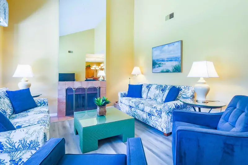 The home features a spacious livng room with vaulted ceilings, two sofas and two armchairs.