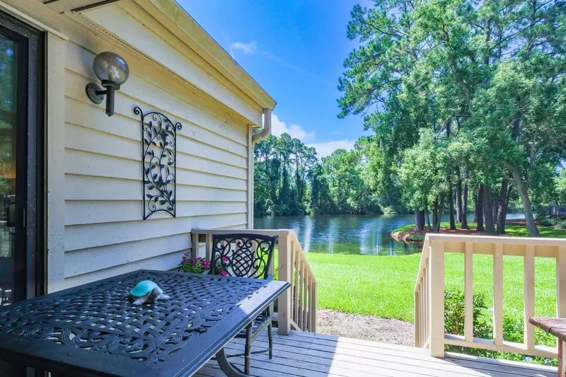 The dining table on the back deck is adjacent to the sliding glass door to the primary suite.