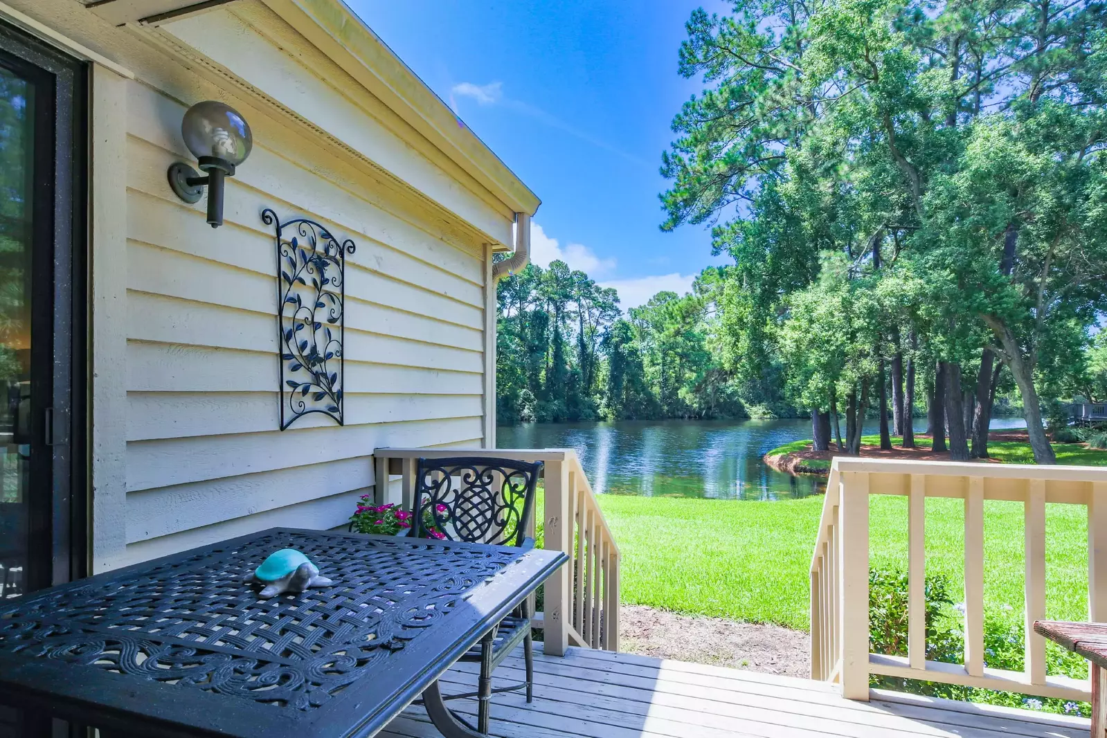 The dining table on the back deck is adjacent to the sliding glass door to the primary suite.
