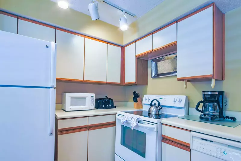 The kitchen features a refrigerator, electric range, dishwasher, microwave, coffee maker and toaster.