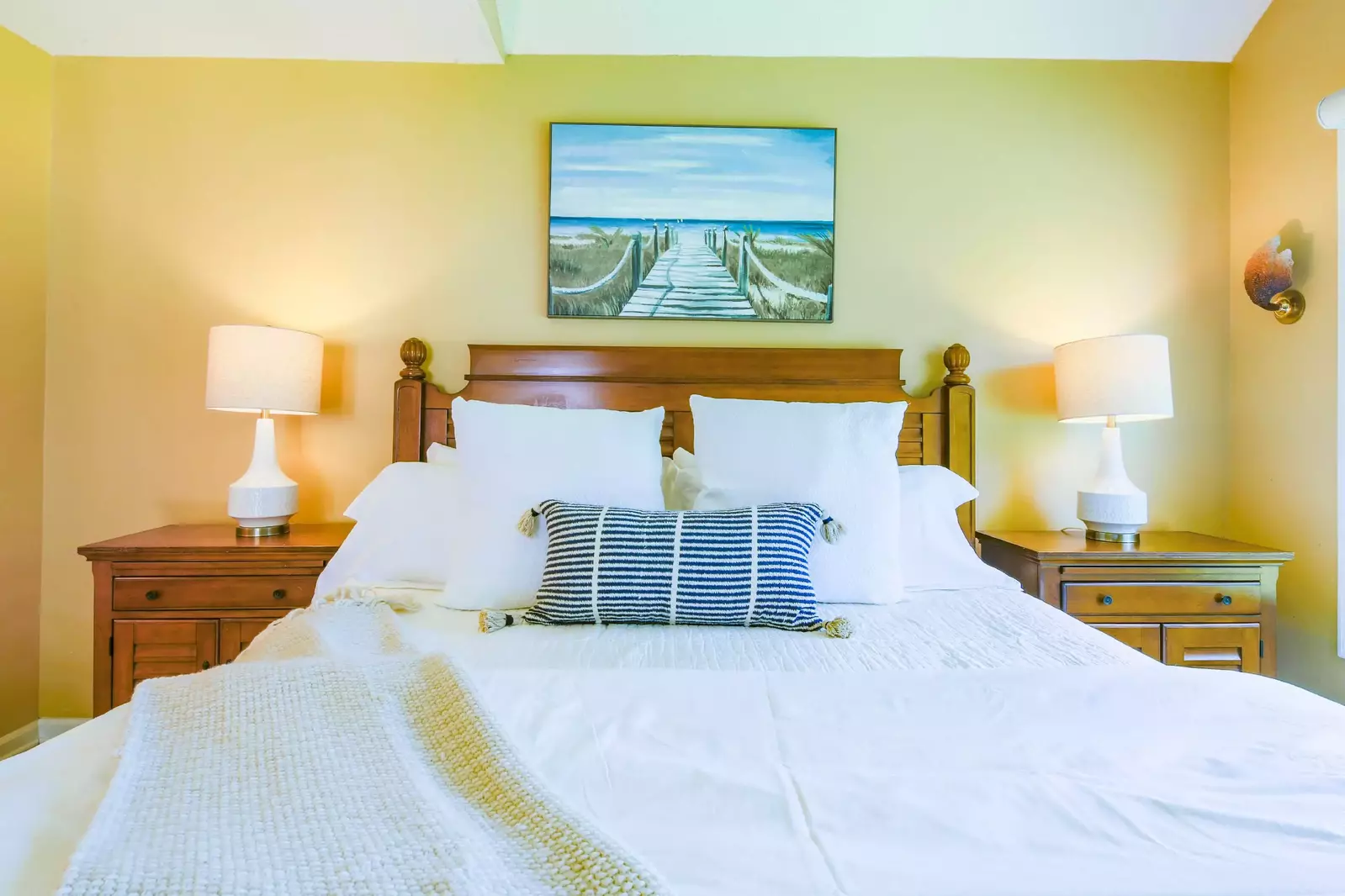 The primary suite features a king bed and night stands with reading lamps.