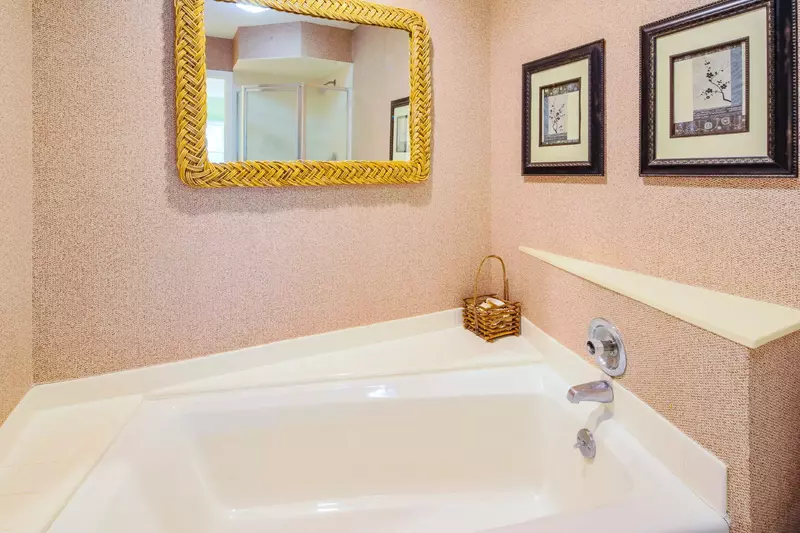 The en suite bathroom has a walk-in shower and a separate bath tub.