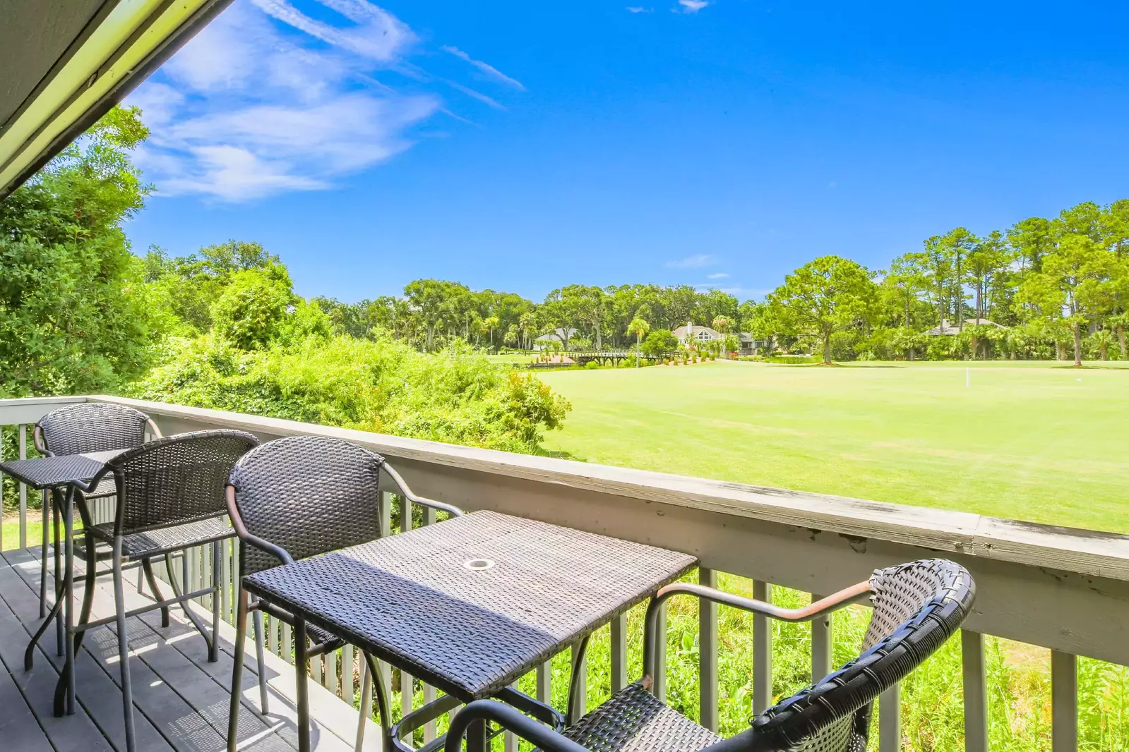The back deck features fabulous golf course views and two dining tables.