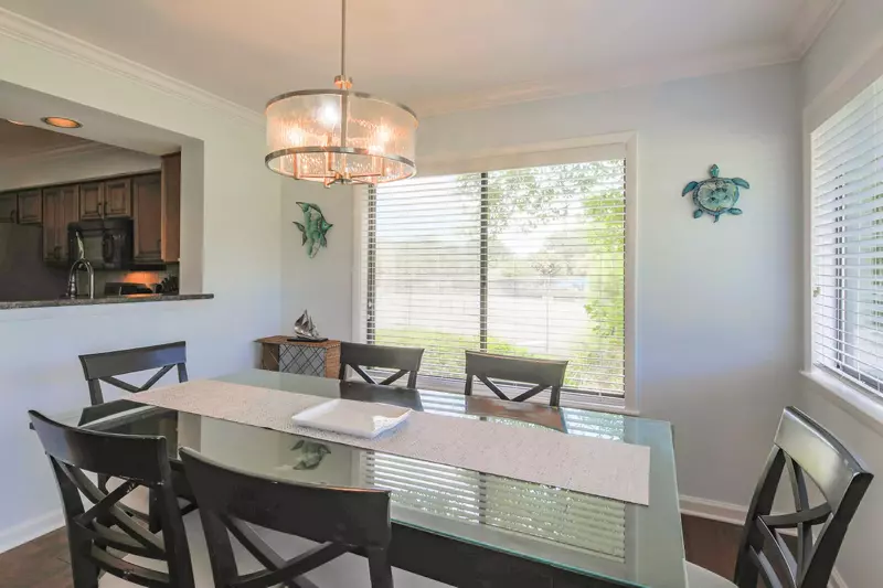 The dining table, which is located near the kitchen and the living room, seats six.