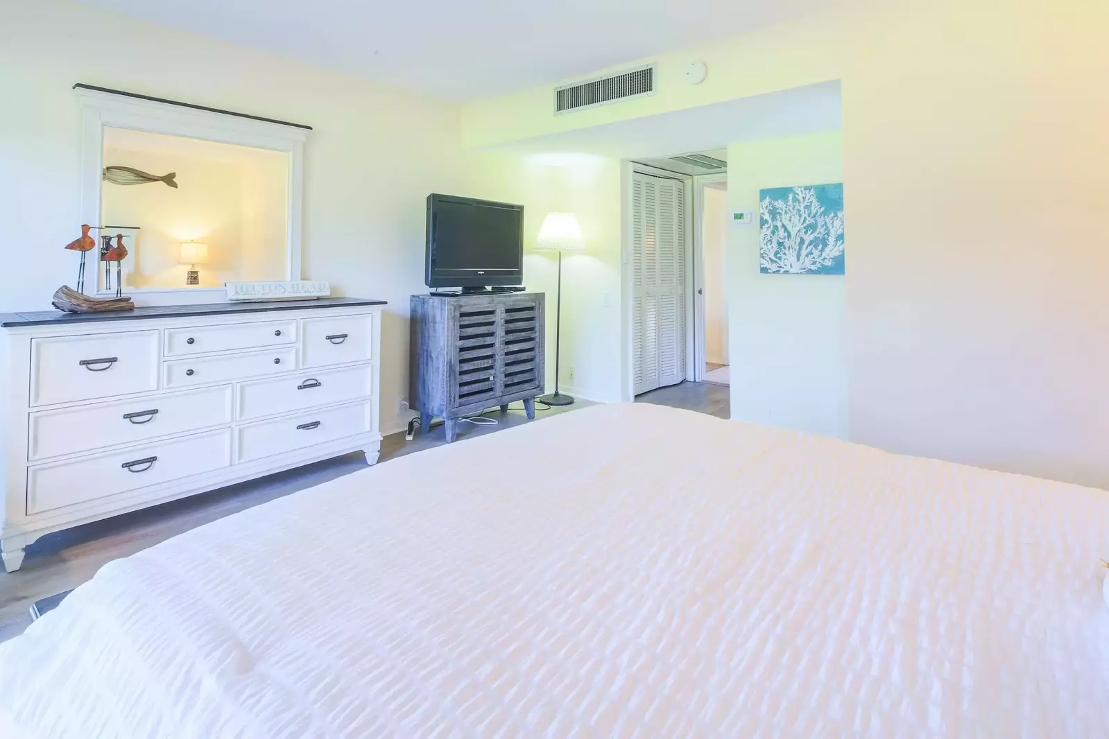 This lower level suite also features a dresser, TV, floor lamp and closet.