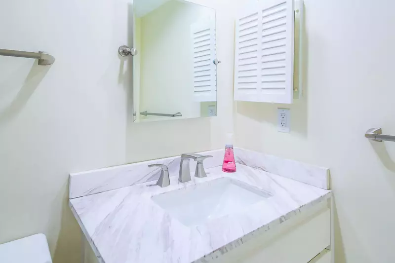 The en suite bathroom for the lower suite features a vanity and medicine cabinet.
