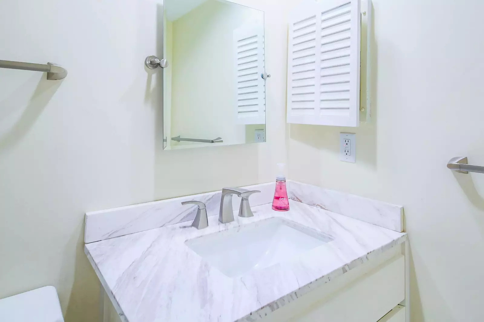 The en suite bathroom for the lower suite features a vanity and medicine cabinet.