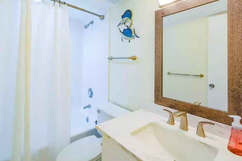 This en suite bathroom also has a shower/tub combo.