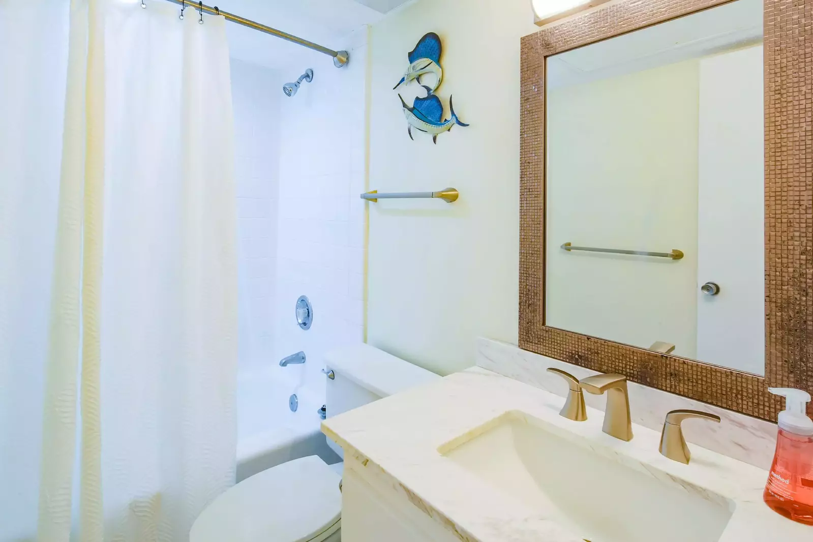 This en suite bathroom also has a shower/tub combo.