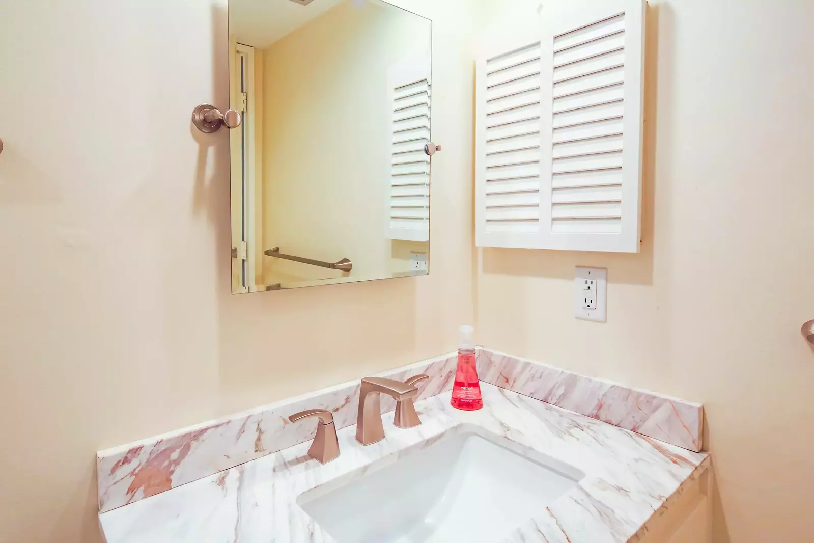 The en suite bathroom features a vanity and medicine cabinet.