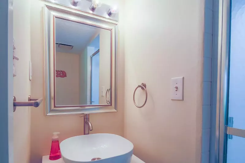 This bathroom with a vanity and walk-in shower is located on the lower level near the living room.
