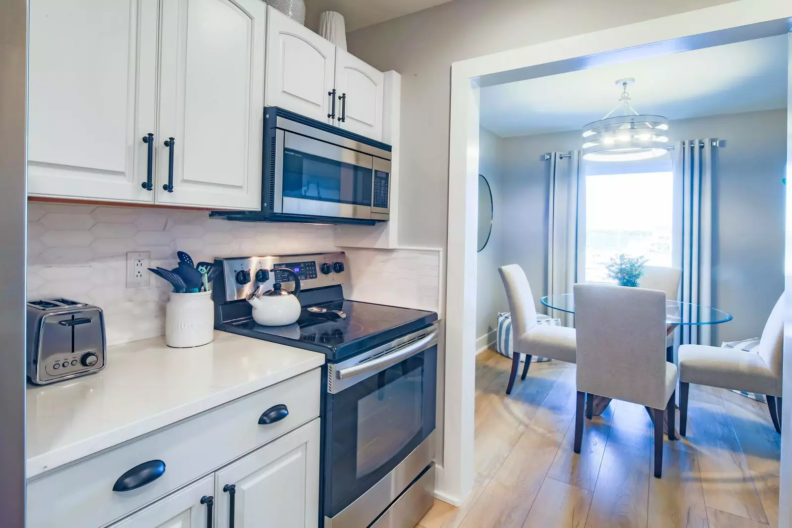 The kitchen features white cabinets, granite counters and a tiled backsplash.