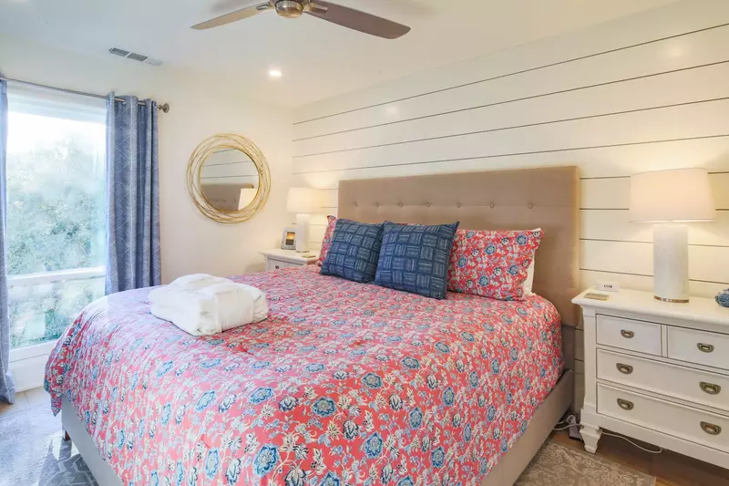 The master suite features a king bed, night stands with reading lamps and shiplap walls.