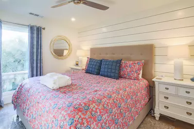 The master suite features a king bed, night stands with reading lamps and shiplap walls.