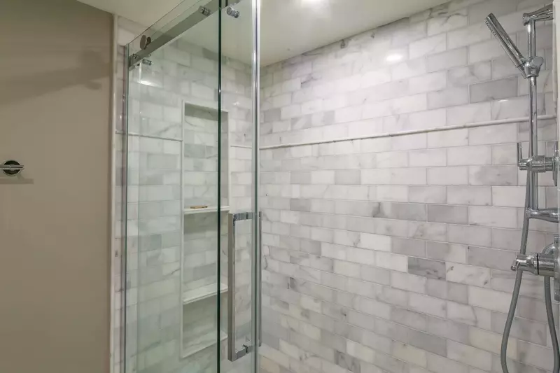 The en suite bathroom also features this beautifully-tiled, walk-in shower.