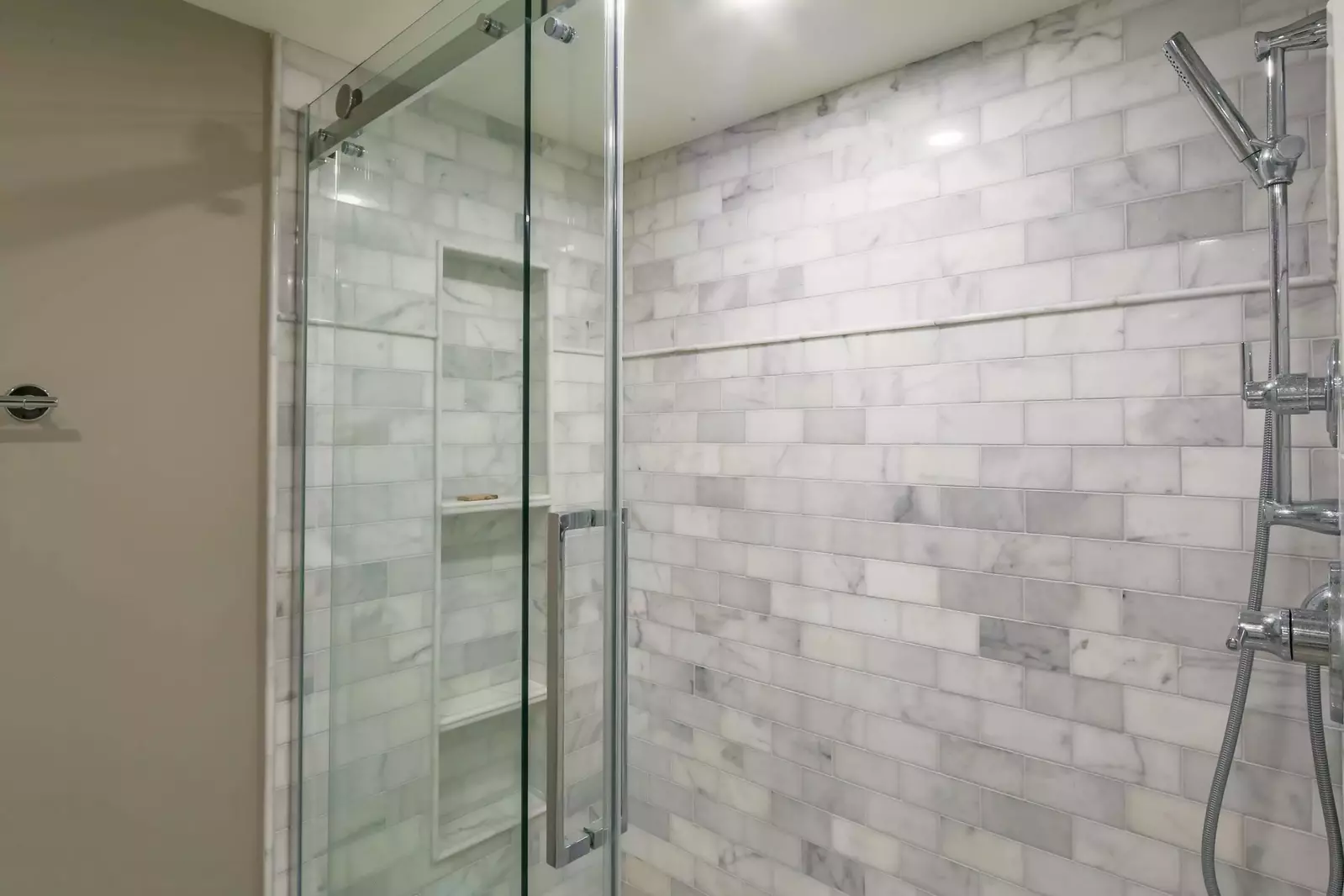 The en suite bathroom also features this beautifully-tiled, walk-in shower.