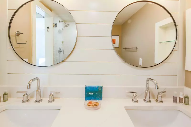The hallway bathroom features a dual sink vanity and shiplap walls.