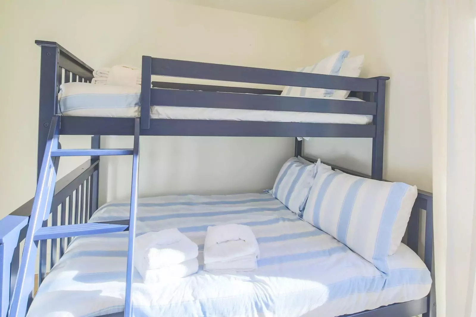 The bunk bedroom features a full bed on the bottom bunk and a twin bed on the top bunk.