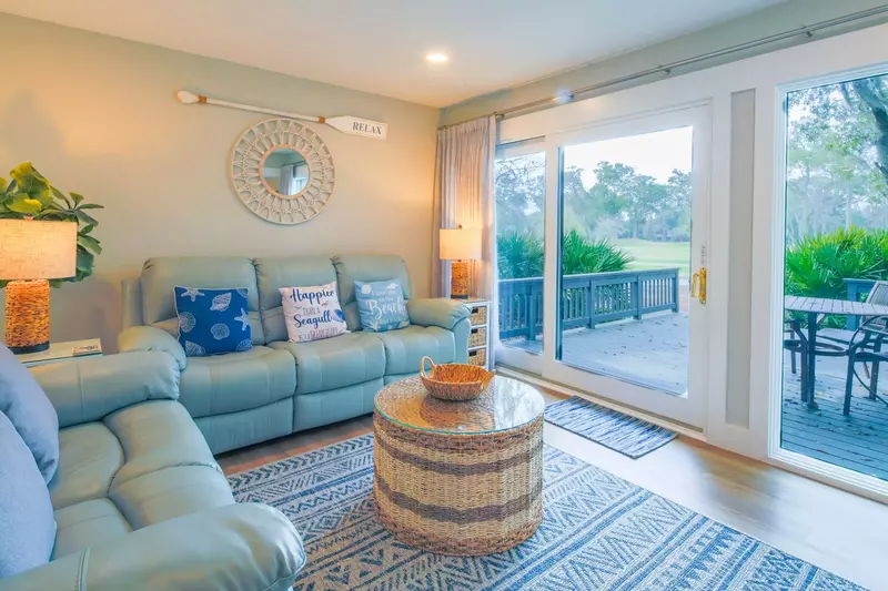 The living room features a spacious seating area and access to the private back porch.