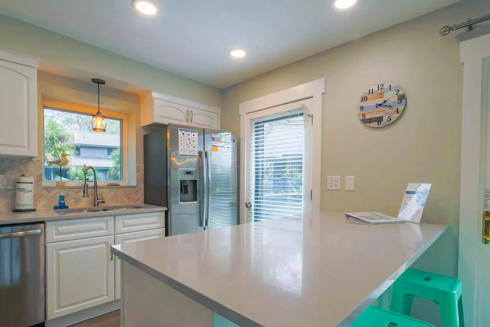The kitchen features stainless steel appliances and a door to the side porch.
