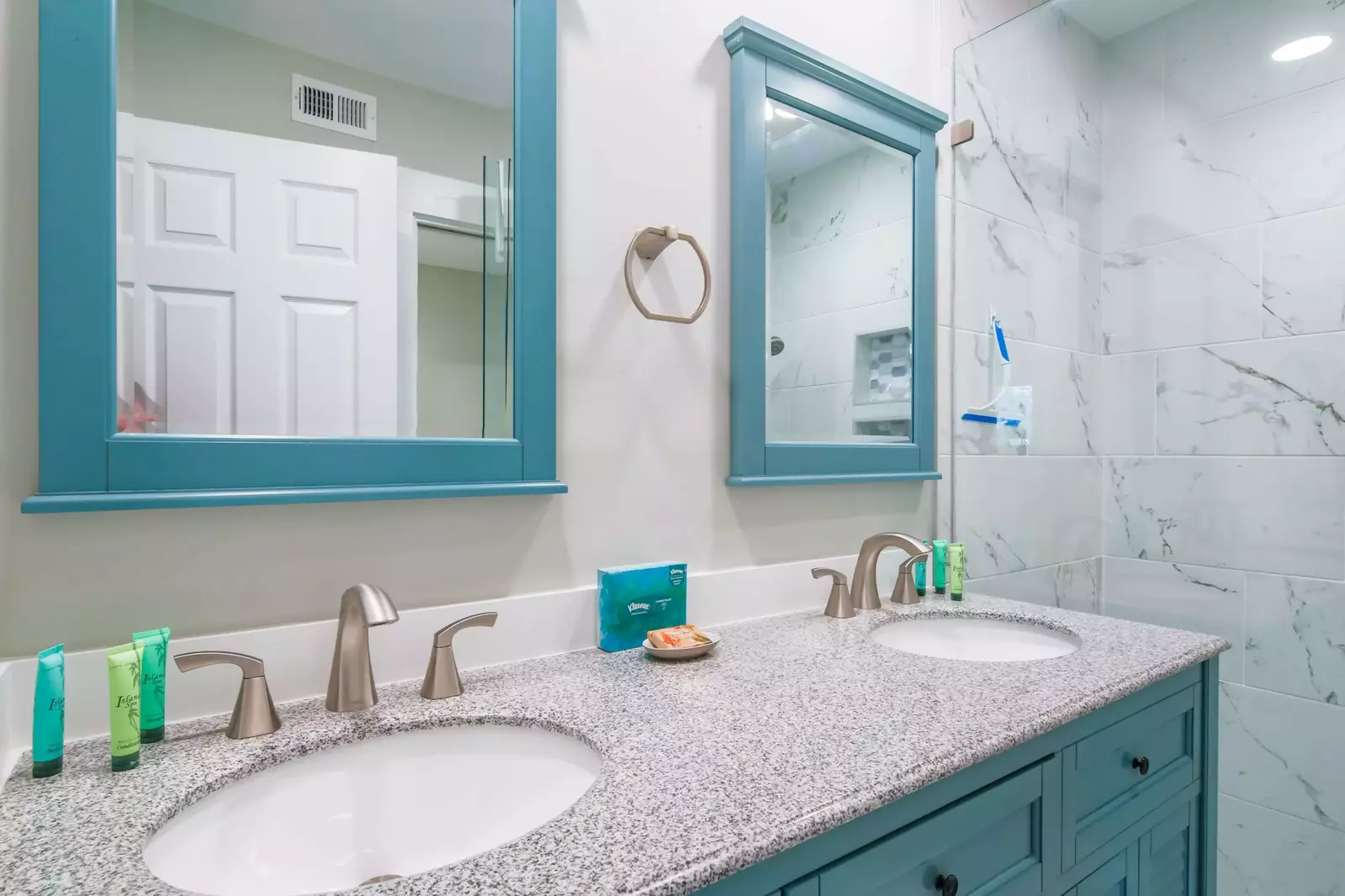 The en suite bathroom for the master suite has a dual sink vanity and tiled, walk-in shower.