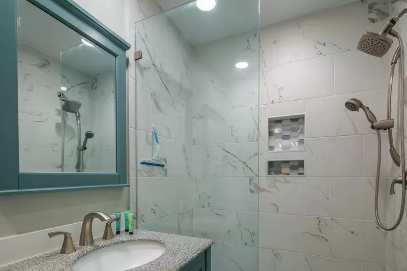 The beautifully tiled walk-in shower has two shower heads.