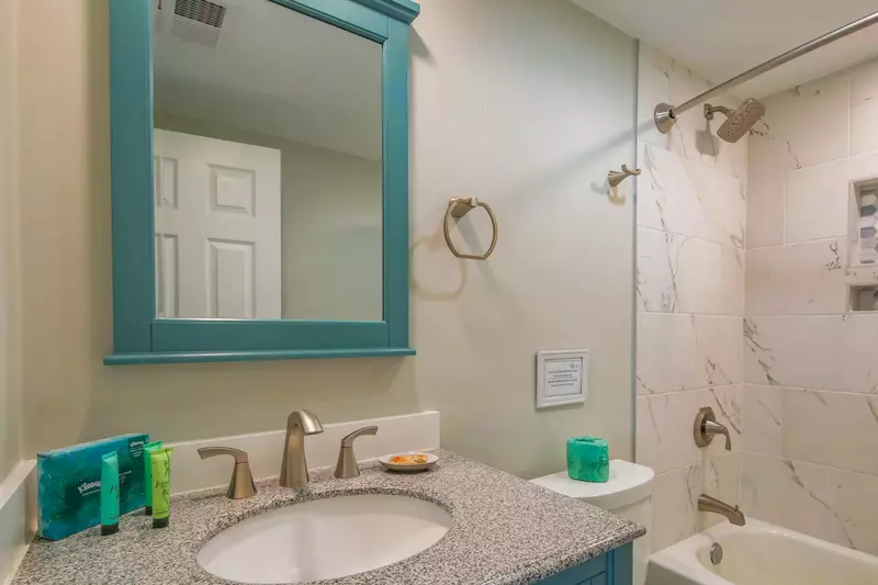 The en suite bathroom features a vanity and shower/tub combo.