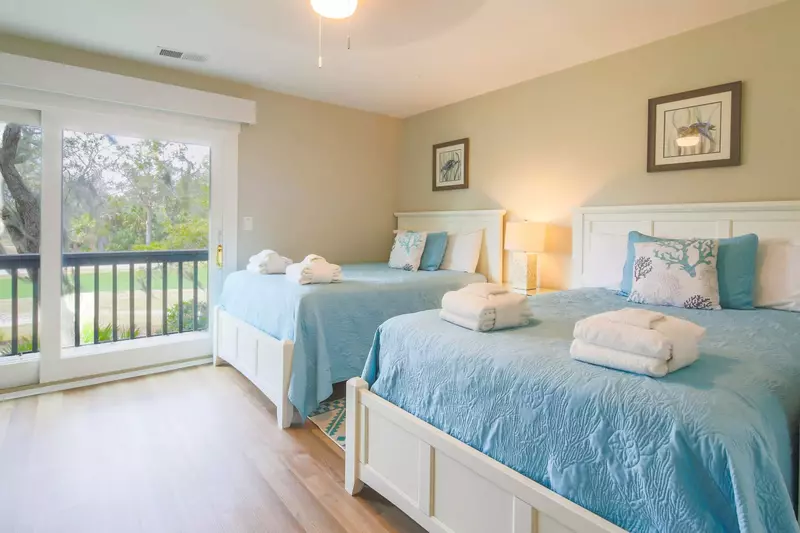 The full suite features two full beds, a night stand with reading lamp and golf course views.