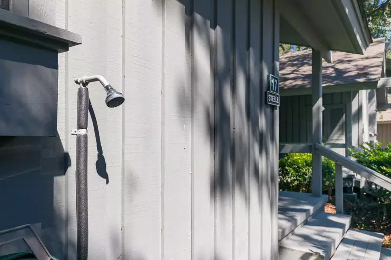 There is an outdoor shower near the stairs to the front porch.