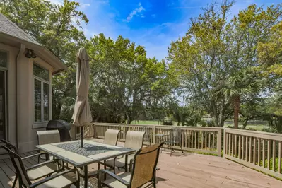 The spacious back deck features golf course views, an outdoor dining table that seats 6 and a gas grill.