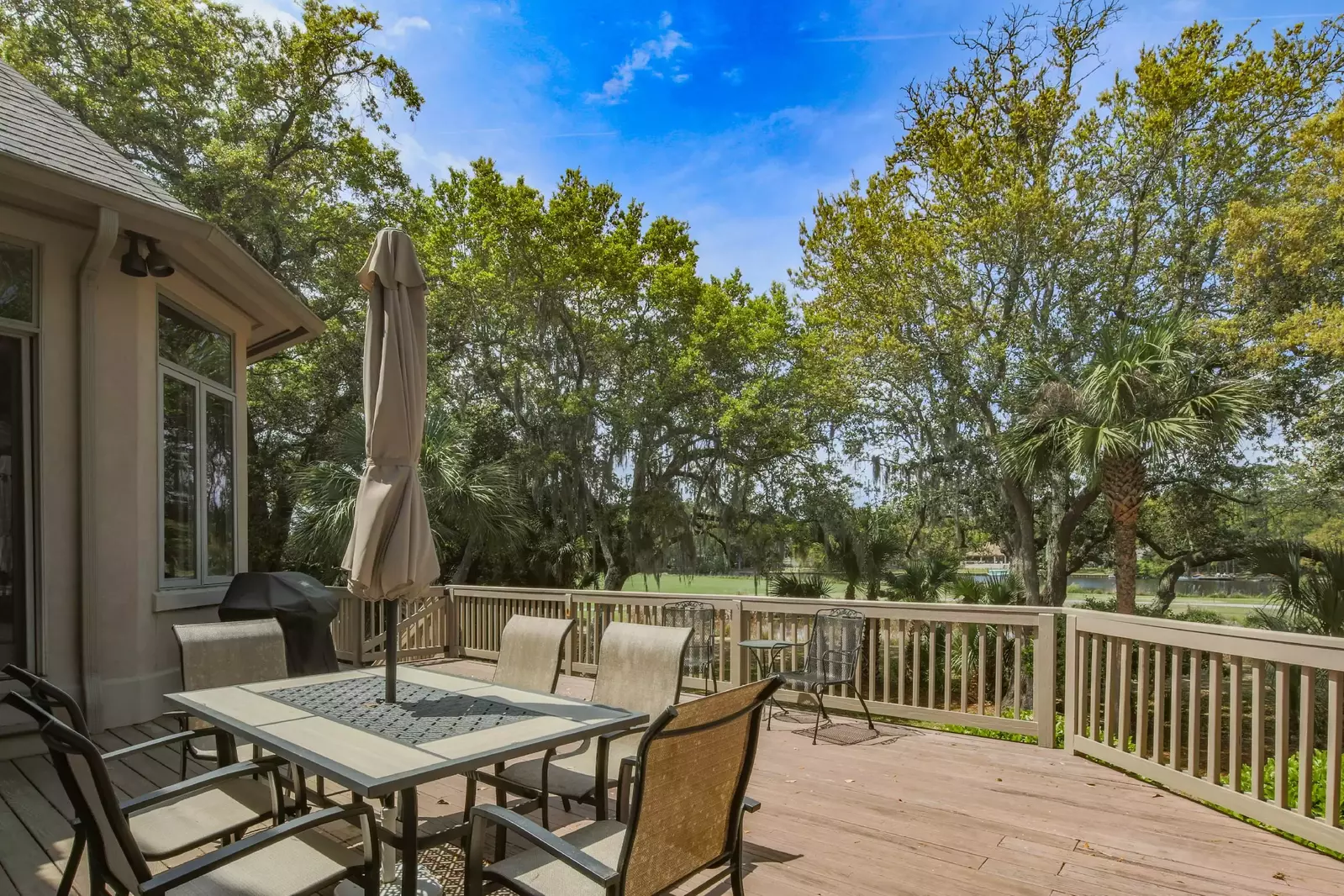 The spacious back deck features golf course views, an outdoor dining table that seats 6 and a gas grill.