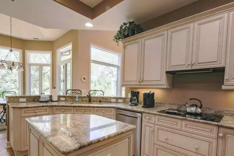 The kitchen features granite countertops and white cabinetry.