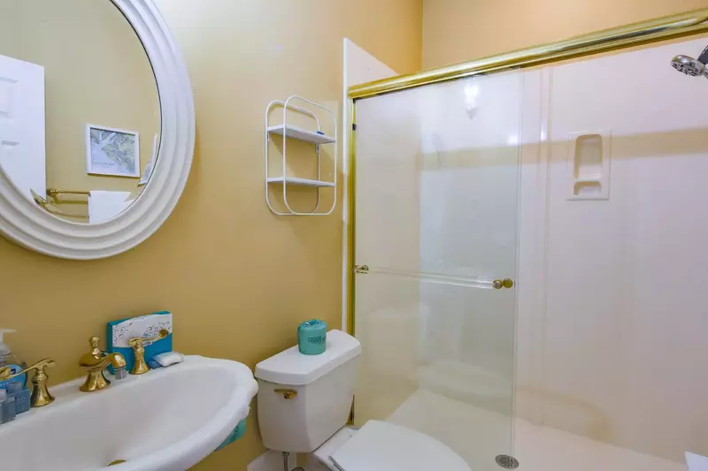 The en suite bathroom for the front suite features a walk-in shower and pedestal sink.