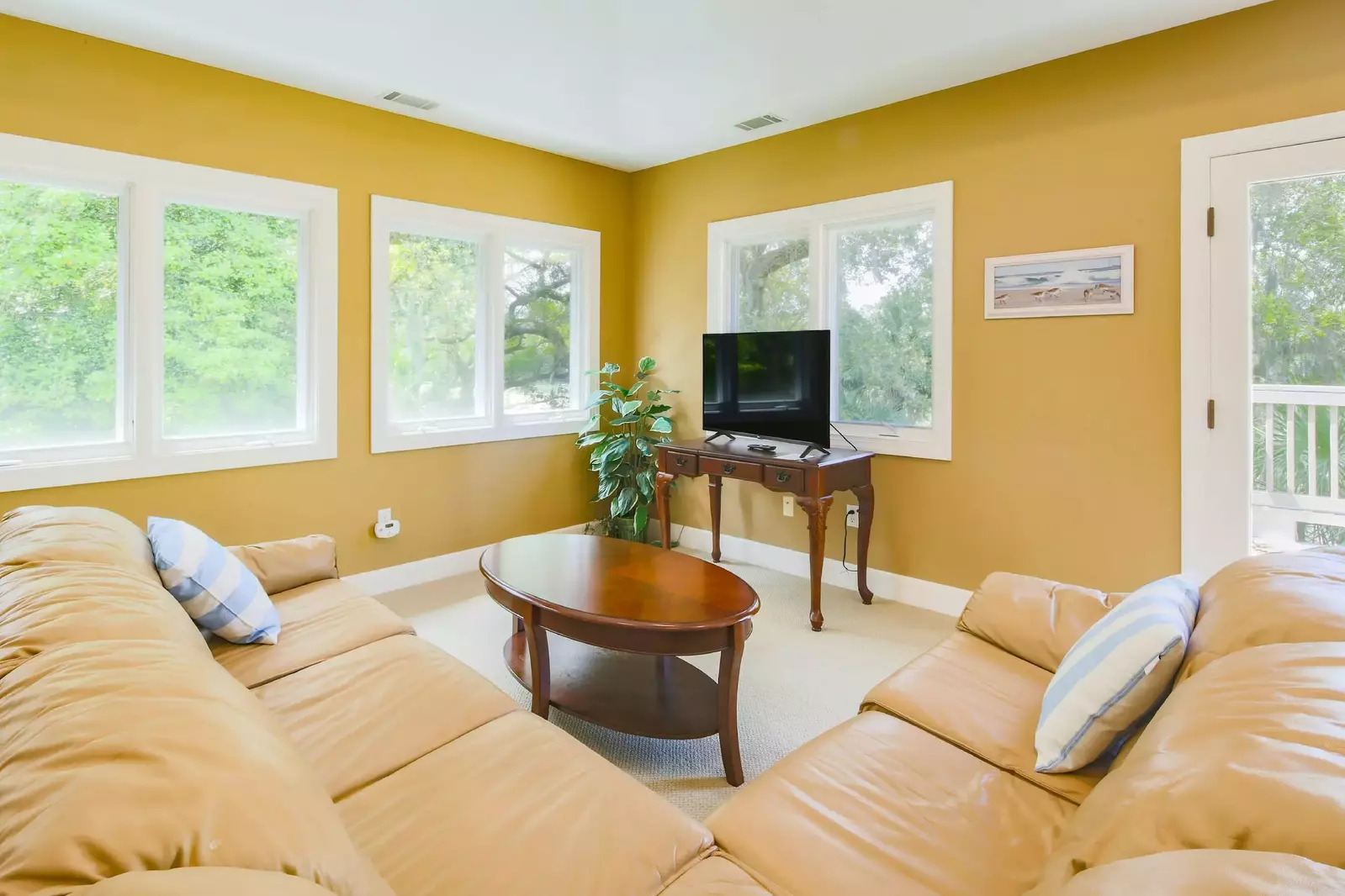 There is a large sectional and flat screen TV within the bonus room.