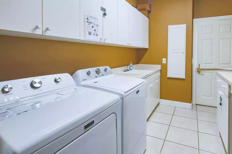 There is a full sized washing machine and dryer in the laundry room.