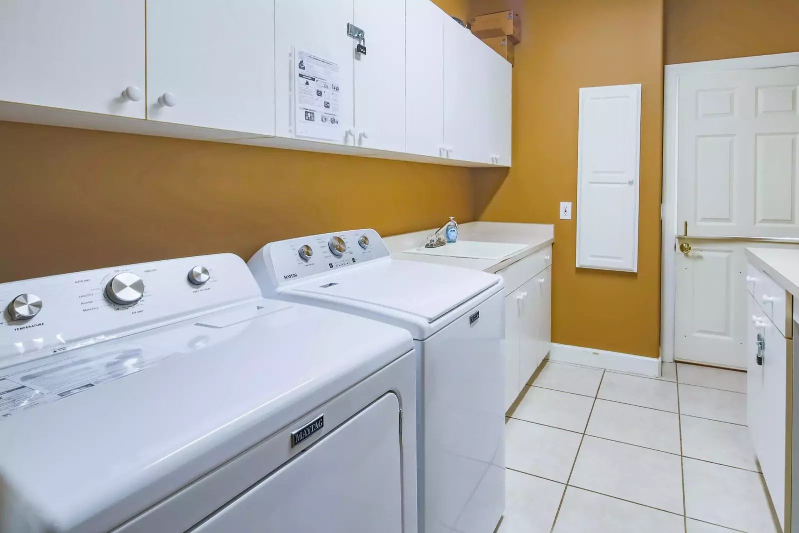 There is a full sized washing machine and dryer in the laundry room.