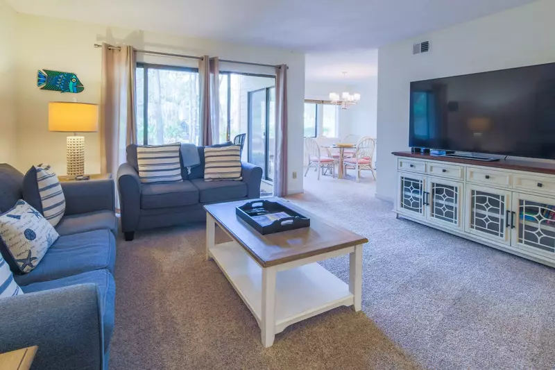 The living room has a large screen TV and connects to both the covered patio and the dining room.