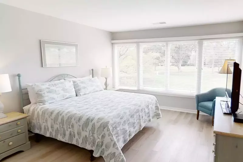 Master Bedroom with King Size Bed, comfortable occasional chair and spectacular golf course views