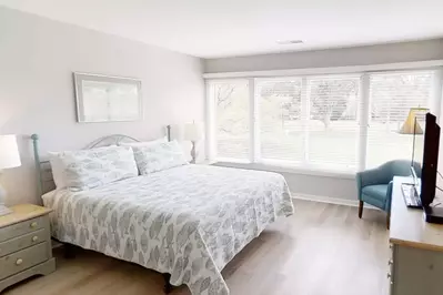 Master Bedroom with King Size Bed, comfortable occasional chair and spectacular golf course views