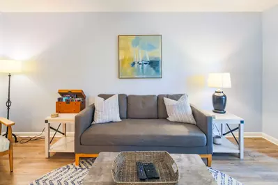 The living room features LVT flooring and a comfortable sofa.