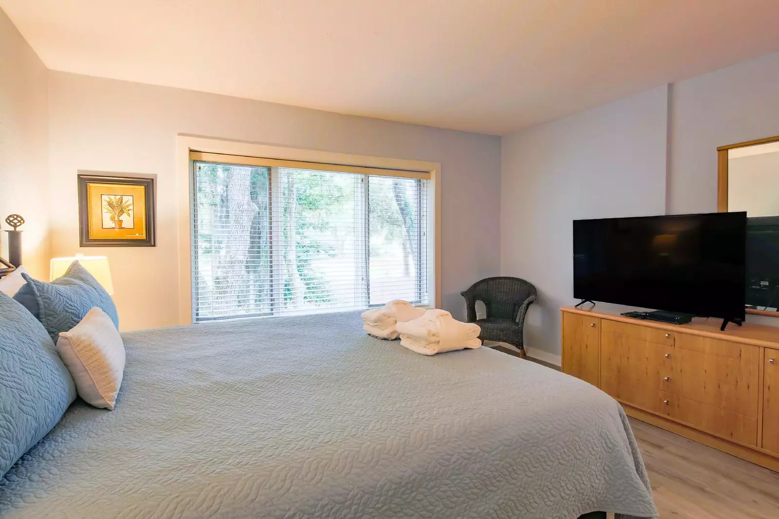 The master suite also has a dresser, flat screen TV and chair.